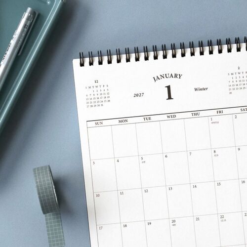 A desk scheduler and matching wall calendar appear together, showing the complementary desktop and wall formats.