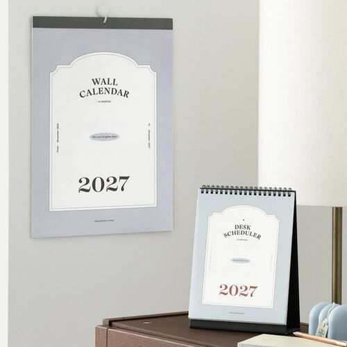 Set beside a wall calendar, the desk version keeps the current month within easy reach on a wooden table.