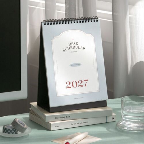 Soft window light falls across the cover, emphasizing the restrained typography and pale blue background.