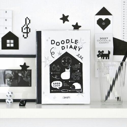 A sticker sheet sits next to an open weekly spread filled with Korean writing and small illustrated decorations.