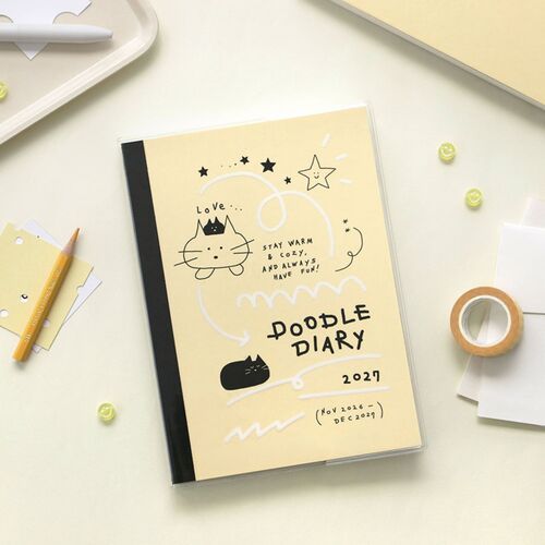 The planner is styled beside a laptop and stationery, showing how the illustrated cover fits a work desk.