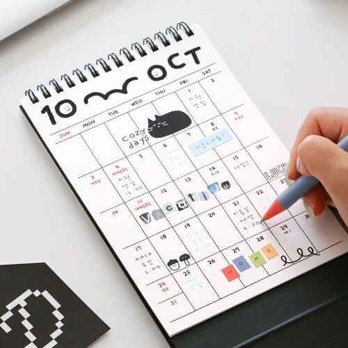 Photo 3: The October calendar page shows a large writable grid with doodled cats, stickers, notes, and colorful accents.