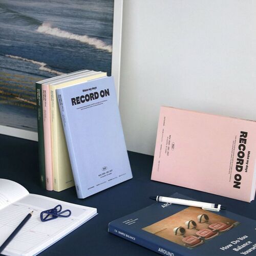 A tabletop arrangement shows the four covers with a weekly spread and pen nearby for scale and use.