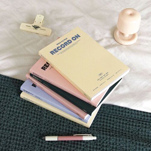 The final image presents the planner on a shelf beside stationery, reinforcing its neat desk-friendly format.
