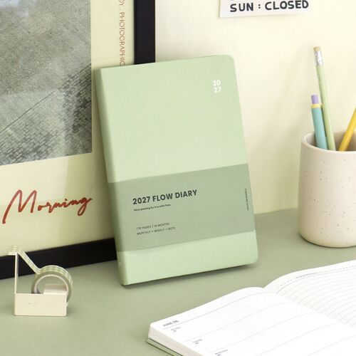 Beige is displayed on a brown surface with writing tools, emphasizing the understated cover and contrasting printed band.