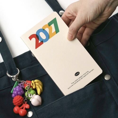 An open planner shows dated daily writing space beside a decorated monthly page.