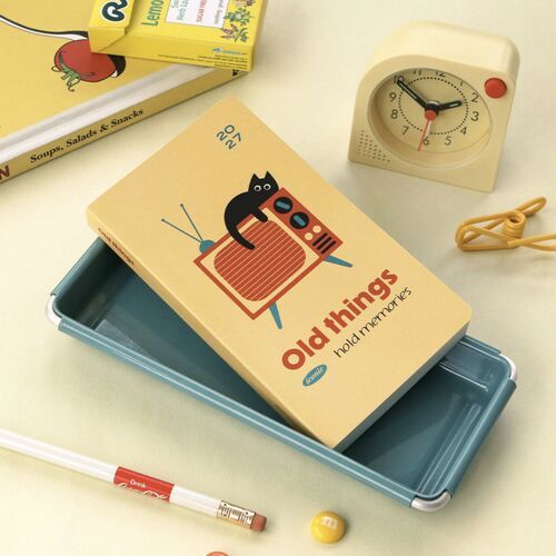 The Moments cover is held against a bag, showing its compact format for carrying.