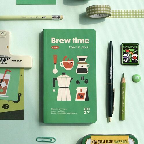 A planner rests beside a punch-style organizer and coffee illustration, reinforcing its stationery-focused design.
