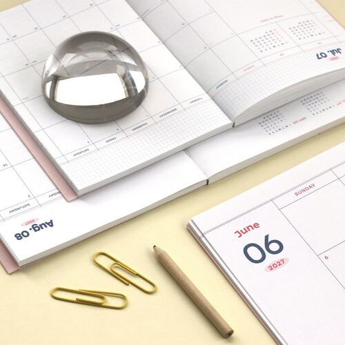 Misty Pink planner is styled with a pen and paper pieces, illustrating how the cover’s pen holder fits into daily planning.