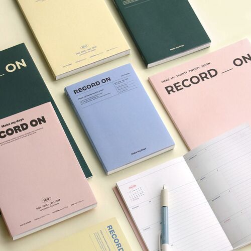 The planners are arranged across dark shelving with varied orientations, making the clean typography easy to compare.