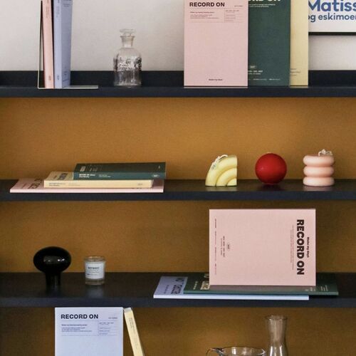 A tabletop arrangement pairs the four cover colors with a pen, washi tape, and an open weekly spread.