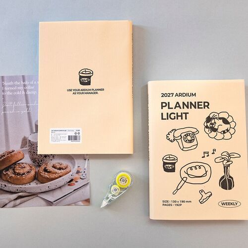 Blue Blooming and Ribbon Cat appear with stationery around them, showing how the planner fits naturally into a desk setup.