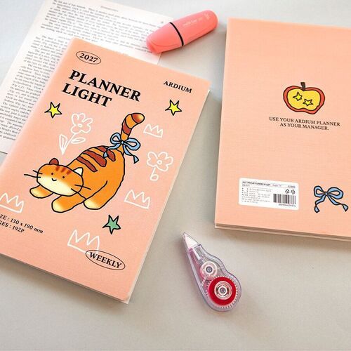 Several planner pages and covers surround a decorated journaling spread with stickers, photos, and handwritten notes.