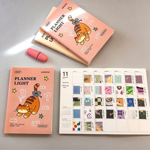 The open planner shows gridded pages filled with photos, stickers, and handwritten notes for creative journaling.