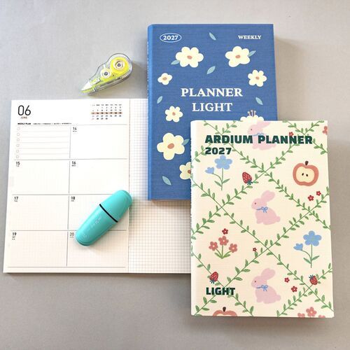 The Blue Blooming cover is shown beside an open monthly spread with large dated boxes and room for scheduling.