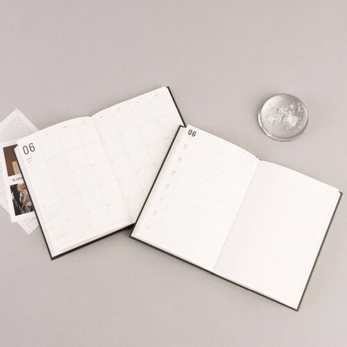 Four pastel hardcover planners are arranged around a pencil, showing their clean covers and compact book format.