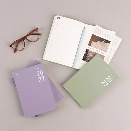 Open planner spreads display a roomy monthly calendar beside a lined weekly planning layout.